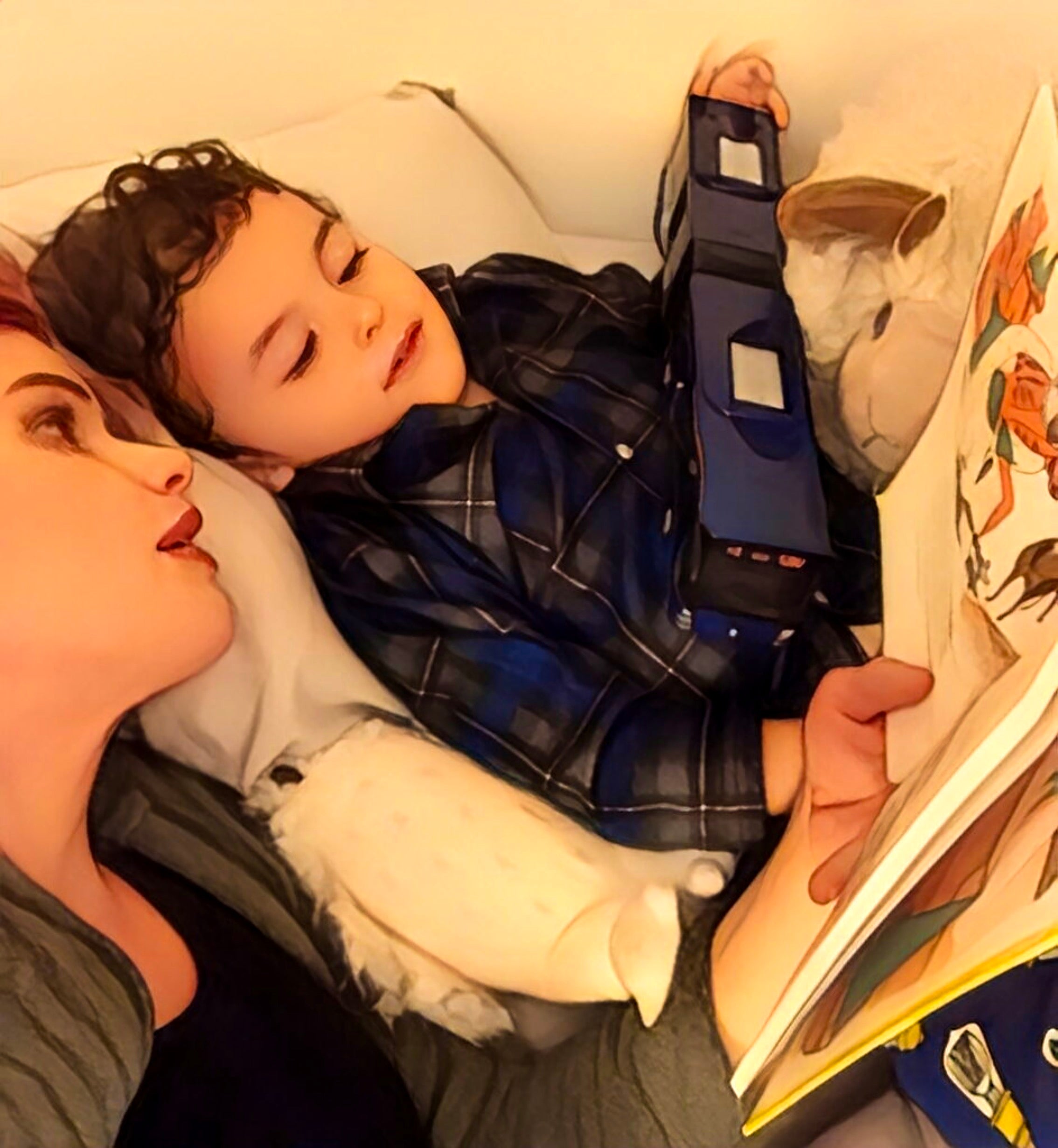 Mother reading to young son in bed