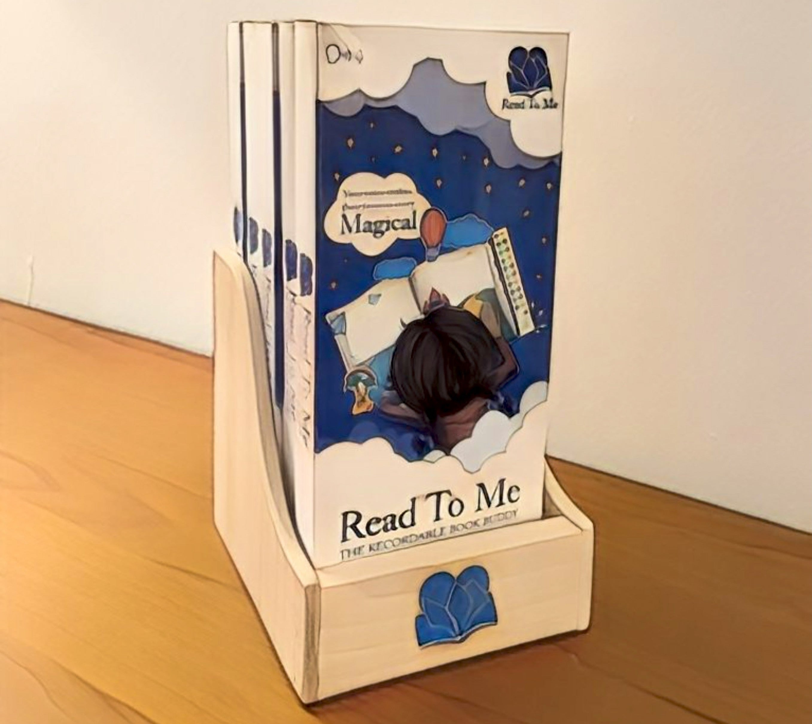 Children's book audio device titled 'Read To Me' with a wooden stand on a wooden surface.